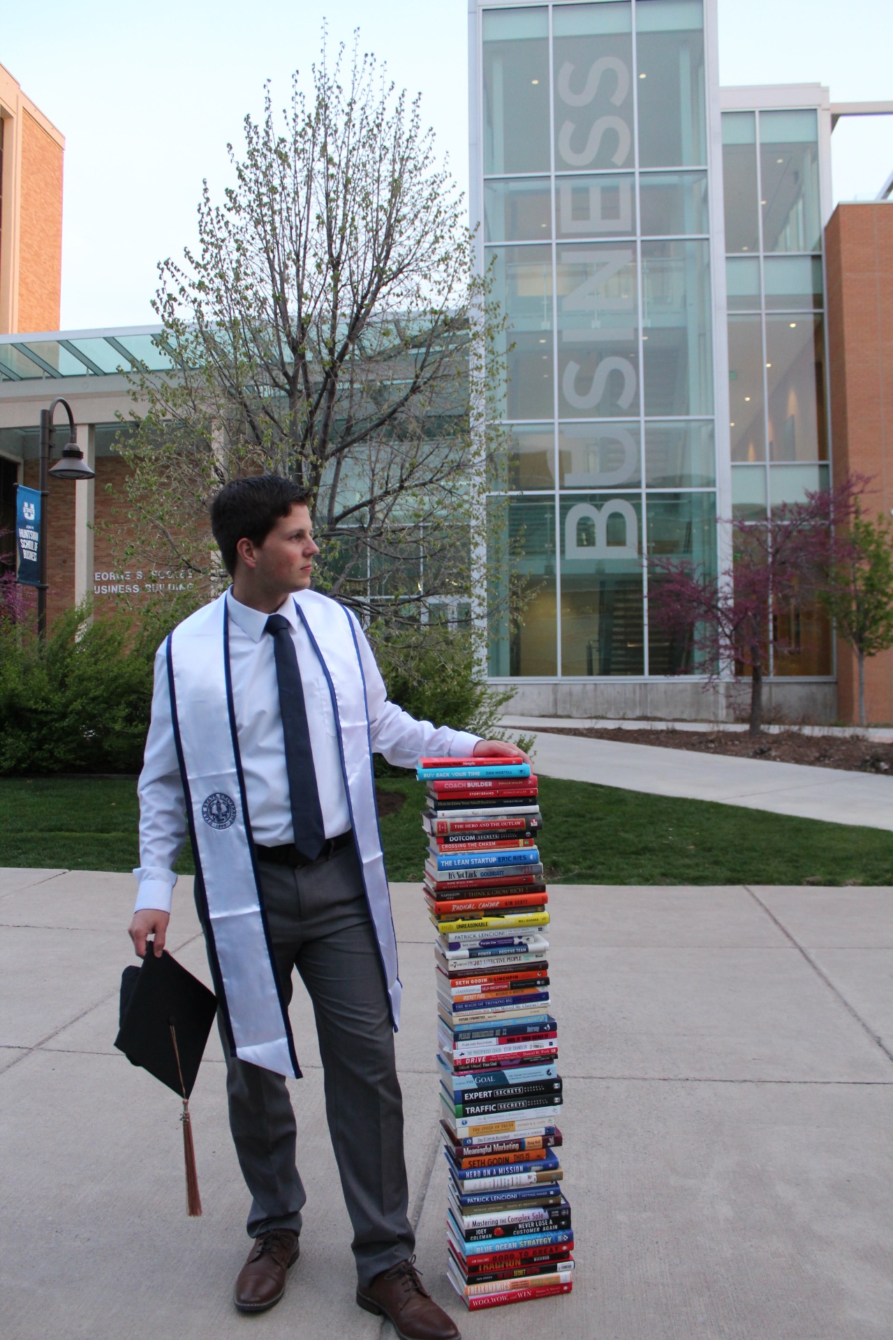 Ben Anderson at the Huntsman School of Business with a stack of marketing and business books
